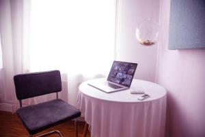 a laptop sitting on a table with a chair at Huge Apartment with Home Cinema and Kitchen in Friedrichshain in Berlin