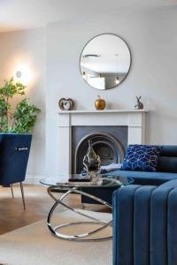 sala de estar con sofá azul y espejo en Baker st / Marylebone / Sherlock Holmes 3Bed2Bath, en Londres