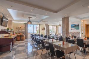 a restaurant with tables and chairs in a room at Minna Apartments in Utjeha