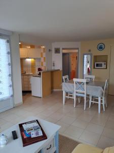 a kitchen and a living room with a table and chairs at Appart 2-3 personnes proche plage de la Fresnaye in Saint-Cast-le-Guildo