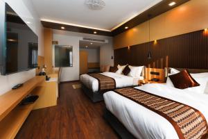 a hotel room with two beds and a flat screen tv at Prudential Hotel Nepal in Kathmandu