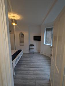 ein Schlafzimmer mit einem Bett, einem Fenster und einem Stuhl in der Unterkunft The Manor Guest House in Wembley in London