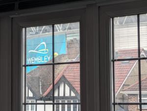 uma janela com um sinal de memphis mercury em The Manor Guest House in Wembley em Londres