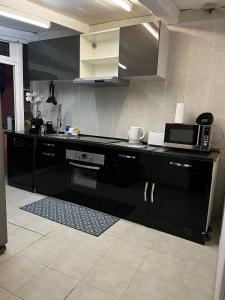 a kitchen with a black counter and a microwave at Petit coin de paradis in Menton