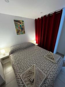 a bedroom with a bed with a red curtain at Petit coin de paradis in Menton