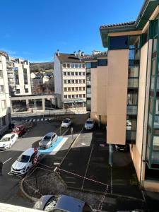 un parking dans une ville avec des voitures garées dans l'établissement Confortable T3 juste rénové au cœur d’Aurillac, à Aurillac