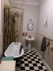 a bathroom with a bath tub and a sink at Hebble End View B&B in Hebden Bridge