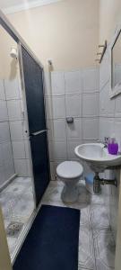 a bathroom with a shower and a toilet and a sink at Pousada Palmeira in Viracopos