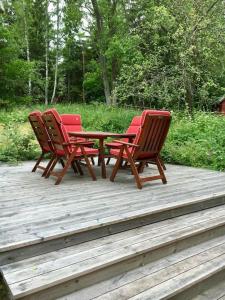 4 sillas y una mesa en una terraza de madera en Lantligt boende nära Kastelholms golf och Smakbyn, 