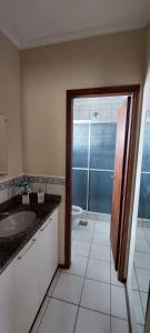 uma casa de banho com um lavatório, um WC e uma porta em Pousada Palmeira em Viracopos