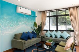 ein Wohnzimmer mit Sofa und blauen Wänden in der Unterkunft Villa w/ Pool-Nimman(near Maya) Chiangmai by Fahsai in Chiang Mai