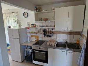 małą kuchnię z białymi szafkami i zlewem w obiekcie Apartment Buric w mieście Županje