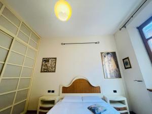 Un dormitorio con una cama y una luz en la pared. en Magnolia Italian Hostings, en Bolonia