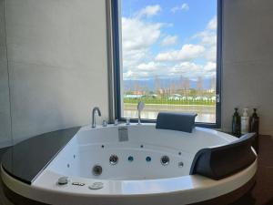a bath tub in a room with a large window at 7star in Guilin
