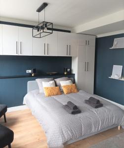 1 dormitorio con 1 cama grande y pared azul en Au cœur de la Grand Place en Arras