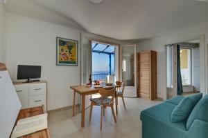 a living room with a table and a blue couch at Bel Horizonte 7 in Capoliveri