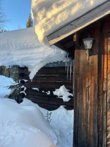 a snow covered cabin with snow on the roof at Bäckstugan in Sälen
