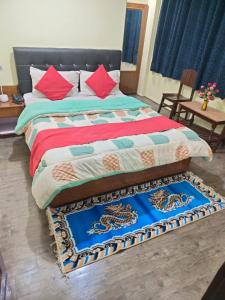 1 dormitorio con 1 cama con mantas y almohadas coloridas en HOTEL TASHI NORLING Near Mall Road en Gangtok
