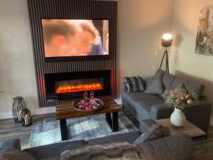 a living room with a couch and a fireplace at Woodside-Filey in Filey