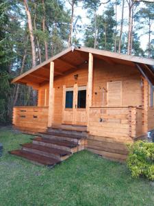 a log cabin with steps leading up to the door at UROCZYSKO POD LASEM in Mikoszewo