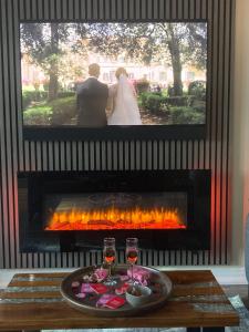 a bride and groom standing in front of a fireplace at Woodside-Filey in Filey