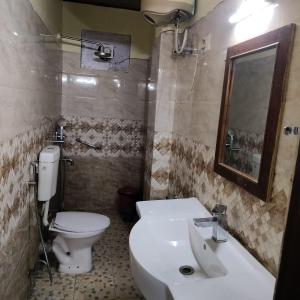 a bathroom with a toilet and a sink and a mirror at HOTEL TASHI NORLING Near Mall Road in Gangtok