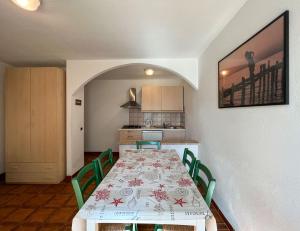 a dining room with a table and green chairs at Mandel Club in Capoliveri