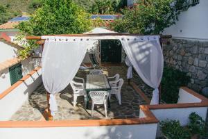 een patio met een tafel en stoelen onder een parasol bij Mandel Club in Capoliveri