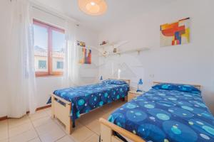 a bedroom with two beds and a window at La Piazzetta di Marciana Marina - Goelba in Marciana Marina