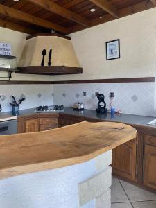 a kitchen with a wooden counter top in a kitchen at Le 53-Maison de campagne-LES MAKES in Saint-Louis