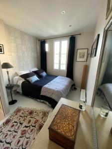 a bedroom with two beds and a table and a window at Montparnasse Paris 15 in Paris