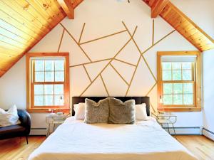 a bedroom with a large bed with a geometric wall at Lake, Kayaks & Sauna - Family & Wellness in Otis