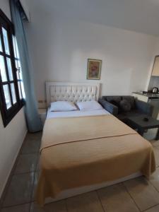 sypialnia z dużym łóżkiem i kanapą w obiekcie Studio Delta sharm Resort w Szarm el-Szejk