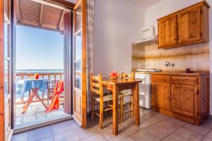 uma cozinha com uma mesa e uma varanda em Nikolaos studios apartments em Skopelos Town