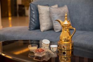 uma mesa de centro com uma chaleira de chá de ouro no sofá em Sanam Hotel Suites - Riyadh em Riade