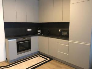 a kitchen with white cabinets and a microwave at Luxurious apartment in the heart of old town with parking in Kaunas