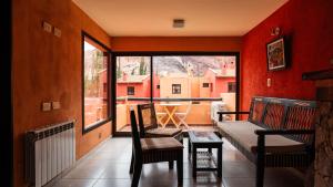 balcón con sofá, mesa y ventana en Colores de Purmamarca en Purmamarca