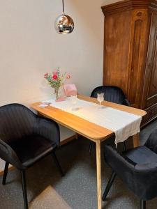 康斯坦茨的住宿－seeglueck SEEBLAU seenah，一张桌子,上面有两把椅子和花瓶