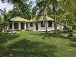 una casa con una palmera en el patio en InVilla Hikkaduwa Sri Lanka en Hikkaduwa
