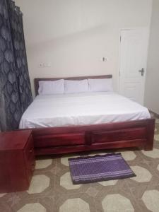 a bed in a bedroom with a white mattress at Hotel Lily in Accra +12 photos