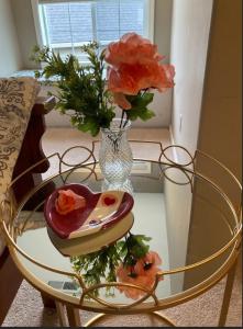 uma mesa de vidro com um vaso e flores sobre ela em Home sweet home em Hillsboro