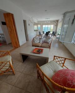 ein Wohnzimmer mit Sofas, einem Tisch und Stühlen in der Unterkunft Casa en El Paraíso Tandil in Tandil