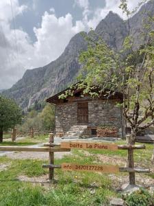 una señal frente a un edificio con una montaña en Baita La Piana - Carona, en Carona