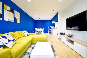 a living room with a yellow couch and a blue wall at 180 Panoramic Views Fully Equipped For 6 Acs in Sofia
