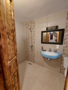 een badkamer met een wastafel en een spiegel bij Riad Azul in Essaouira