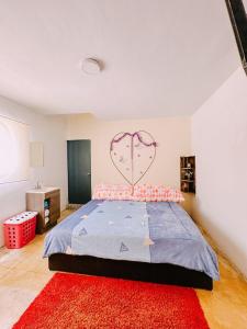 コミタン・デ・ドミンゲスにあるCasa Blancaのベッドルーム1室(壁にハート付きの大型ベッド1台付)