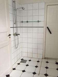 een badkamer met een douche en een zwart-witte tegelvloer bij Romantic villa on old Mansion in Säffle