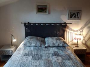 a bedroom with a bed with a blue comforter and two lamps at Au clos des Varnelles in Revigny-sur-Ornain