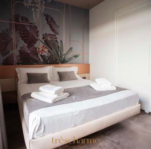 una camera da letto con un letto bianco e asciugamani di Trèscharme ad Andria