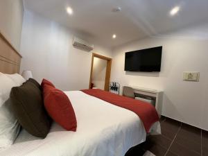 a bedroom with a bed with a tv on the wall at Quinta Solar da Portela in Almodôvar